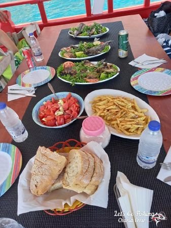 A full table on a Greek boat. Fishing trips in Crete, Greece